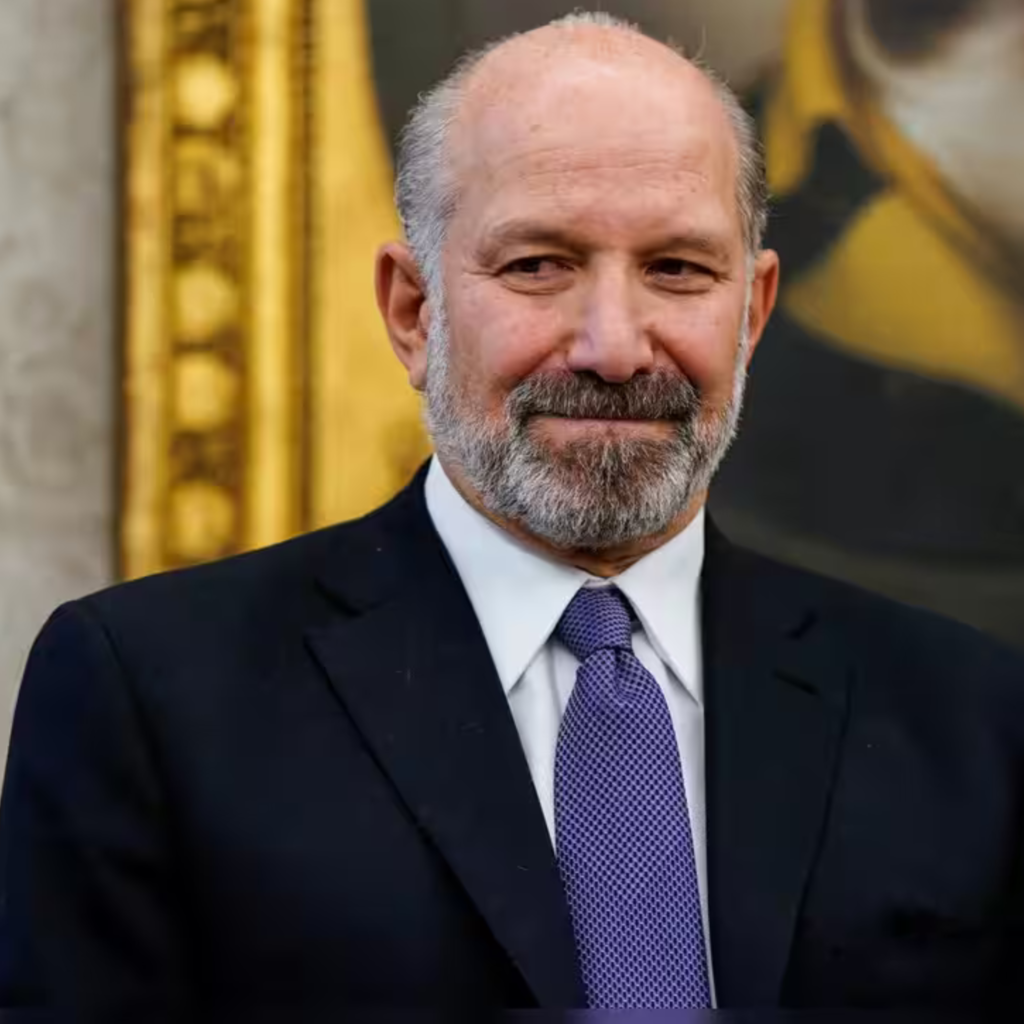 Close-up portrait of Howard Lutnick, U.S. Secretary of Commerce, wearing a dark suit and patterned tie.